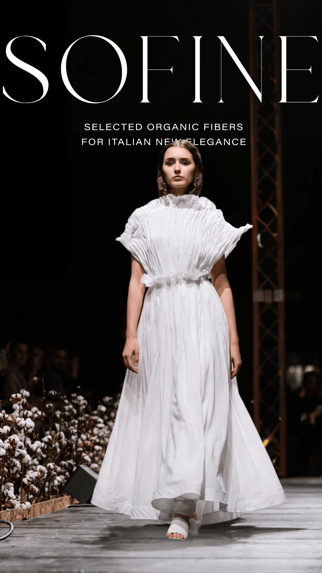 Woman in a white dress holding an organic cotton branch in a SOFINE campaign image